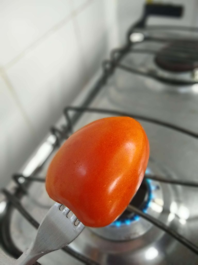 Posicione o tomate sobre a chama girando sempre.
